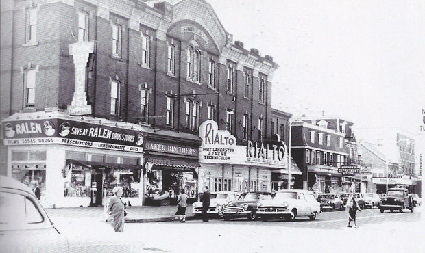 The Rialto Theatre marquee on Broad Street, Woodbury, with Ralen Drug Store on the corner and 1950s cars parked at the curb